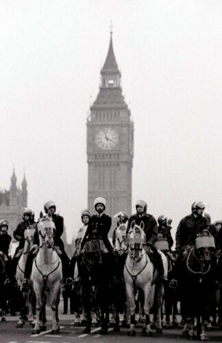 British police on horses, both in riot gear, as described by Alan Moore in the quoted passage.